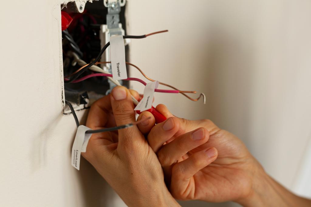 An electrician is replacing a wall switch