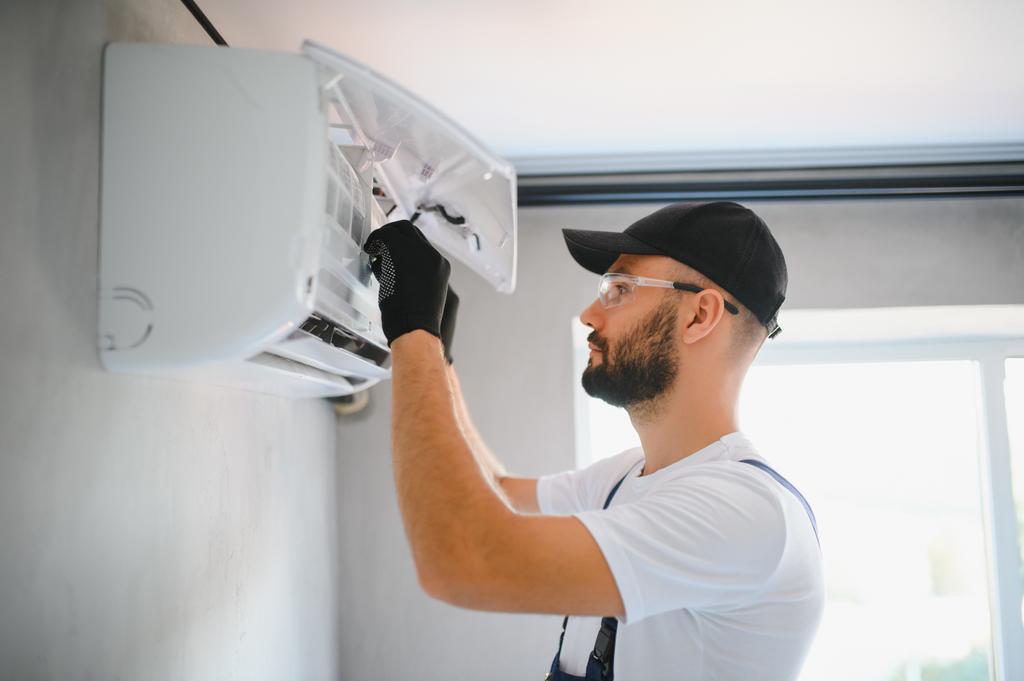 Repairman fixes an air conditioning system